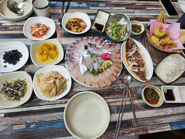 회와 생선구이, 여러 가지 밑반찬이 차려진 상